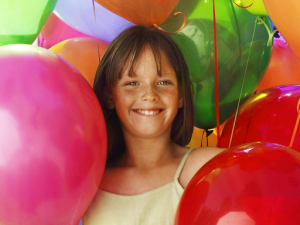 girl surrounded by colorful baloons
